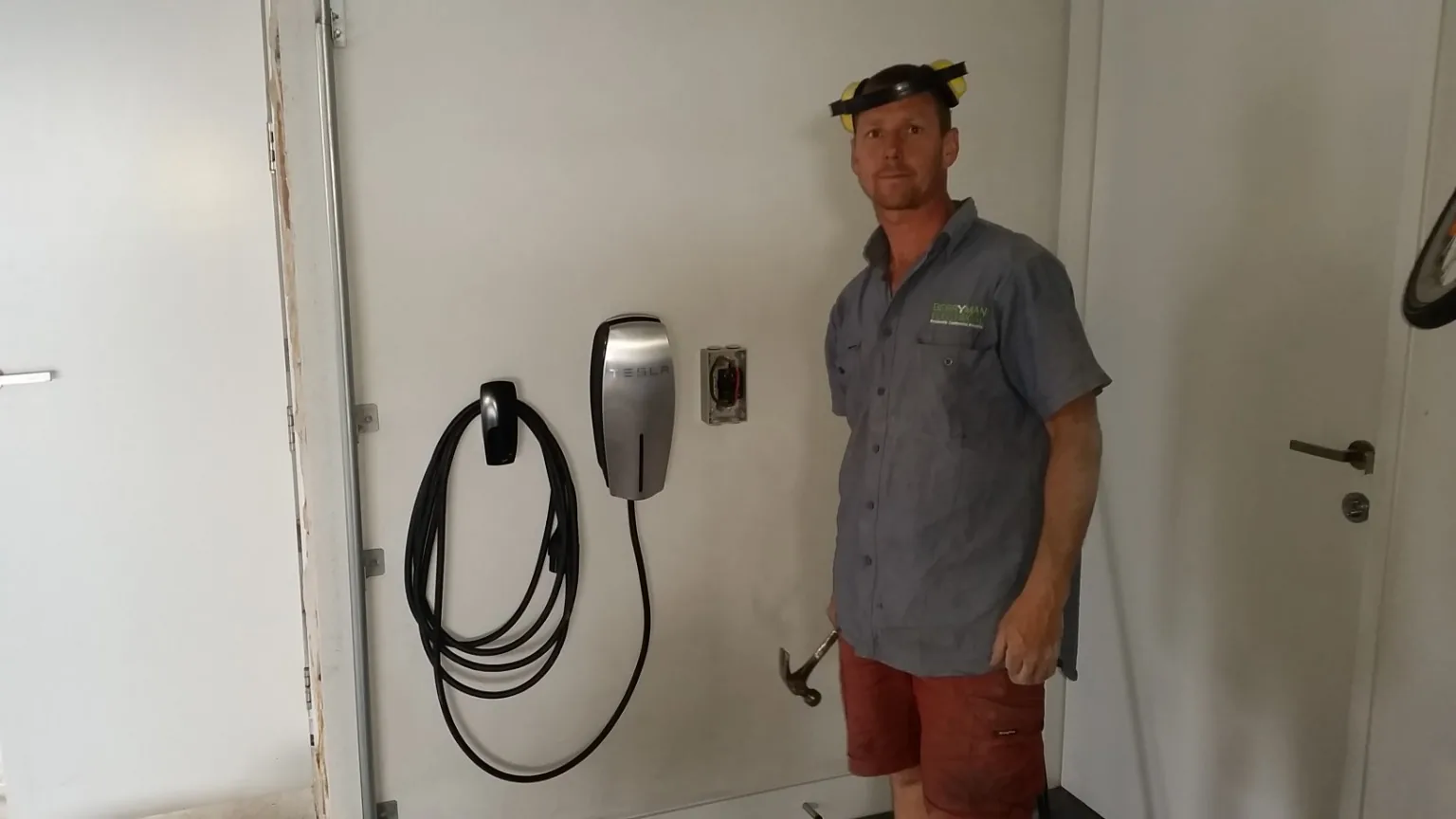 Electrician standing beside completed Tesla Wall Connector installation