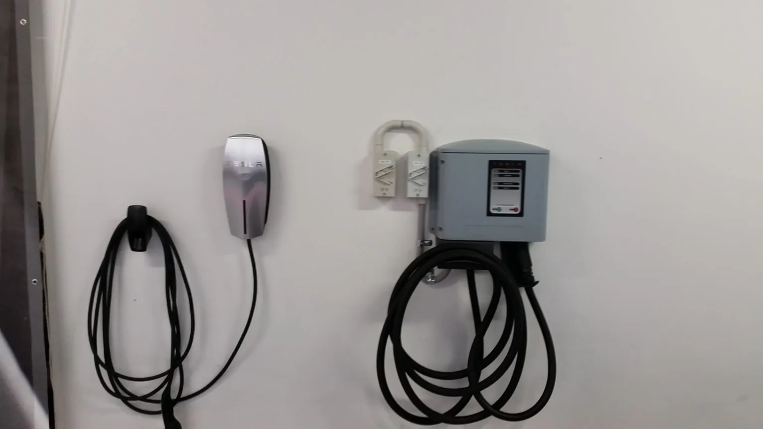Two Tesla electric vehicle charging points installed on a garage wall