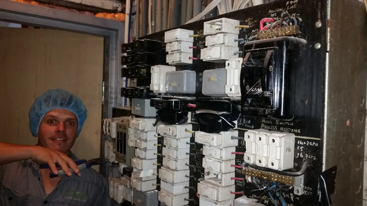 Electrician working at an older electrical switchboard
